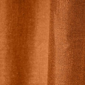Stofdetails van roestkleurige inbetween gordijnen met linnen look uit de Saphira Light collectie van Okika, met zicht op de luchtige structuur.