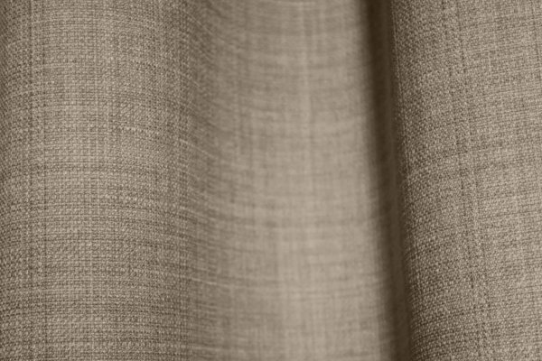 Close-up van het stofpatroon van soft taupe gordijnen uit de Florain collectie (JC2516) van Okika, met een subtiele weving die veel sfeer geeft door gemeleerd effect