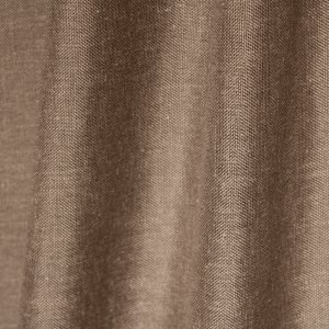 Sfeerfoto van de taupekleurige inbetween gordijnen met linnen look uit de Saphira Light collectie van Okika, soepel hangend en zacht licht doorlatend voor een warme sfeer.