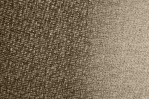 Close-up van de stofstructuur van taupe gordijnen uit de Florain collectie (JC2517) van Okika, met een fijne weving die het daglicht subtiel filteren