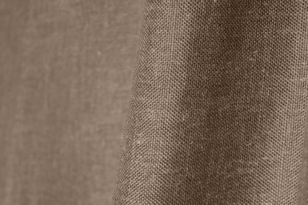 Stofpatroon van taupekleurige inbetween gordijnen met linnen look uit de Saphira Light collectie van Okika, open structuur van de stof met natuurlijke weving.