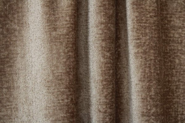 Detail van taupe teddy gordijn BB2411 uit de Okika-collectie. De volle, fluweelzachte teddy-stof voelt comfortabel aan en is perfect voor wie zoekt naar teddy gordijnen op maat met een natuurlijke en luxe look.