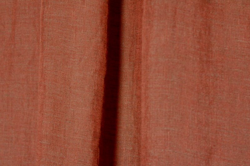 Sfeerfoto van terra linnen inbetween gordijnen uit de Maison collectie van Okika, warm gekleurd en lichtdoorlatend met een natuurlijke uitstraling.
