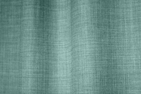 Sfeerfoto van turquoise gordijnen uit de Florain collectie (JC2526) van Okika, die de ruimte een frisse sfeer geven, semi licht doorlatende stof en kleurvast