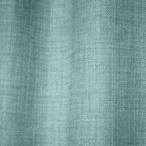 Detailfoto van van turquoise gordijnen uit de Florain collectie (JC2526) van Okika, met een levendige kleur die de ruimte op vrolijkt.
