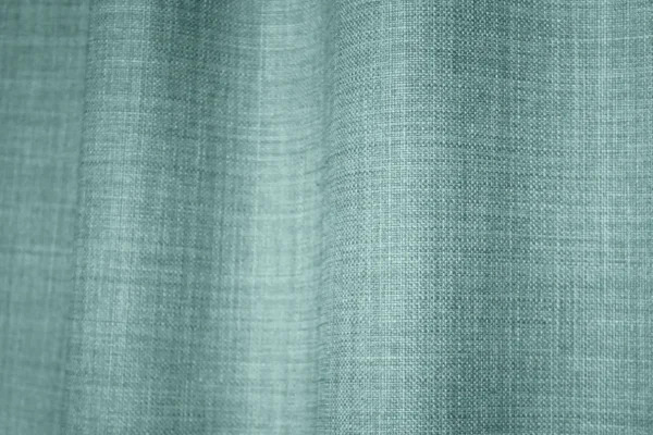 Detailfoto van van turquoise gordijnen uit de Florain collectie (JC2526) van Okika, met een levendige kleur die de ruimte op vrolijkt.