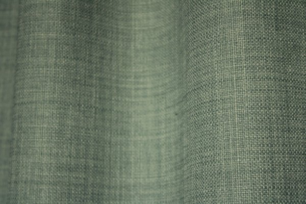 Close-up van het stofpatroon van turquoise gordijnen uit de Florain collectie (JC2526) van Okika, met een fijne weefstructuur die een speelse en heldere uitstraling geeft