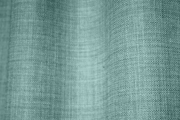 slose-up van het stofpatroon van turquoise gordijnen uit de Florain collectie (JC2526) van Okika, met een fijne weefstructuur die een speelse en heldere uitstraling geeft