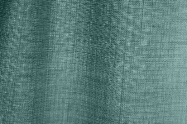 detailfoto van de stofstructuur van turquoise gordijnen uit de Florain collectie (JC2526) van Okika, met een subtiele weving die zorgt voor een frisse en levendige sfeer