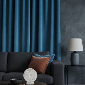 Grijsblauwe velvet gordijnen uit de Renoir-collectie in een industrieel interieur met betonlook en donkere accenten. sfeerimpressie