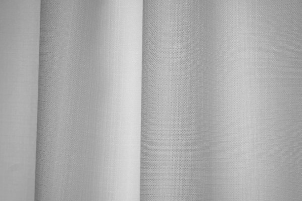 Sfeerbeeld van witte gordijnen uit de Florain collectie in een licht interieur met zachte daglichtinval