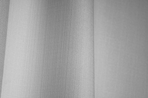 Close-up van het stofpatroon van witte gordijnen uit de Florain collectie (JC2510) van Okika, met een subtiele weving, kleurvast en semi lichtdoorlatend