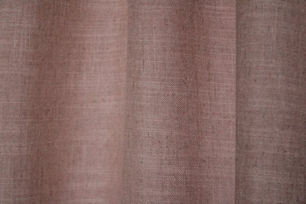 Close-up van zacht roze Elegance gordijnen uit de JC2561 collectie. Effen gordijnstof met een volle structuur en een zachte, elegante uitstraling.