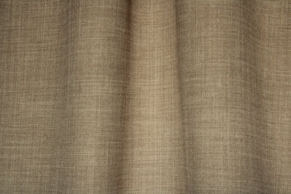 Close-up van het stofpatroon van zandkleurige gordijnen uit de Florain collectie (JC2514) van Okika, met een subtiele structuur, semi lichtdoorlatende gordijnen op maat gemaakt