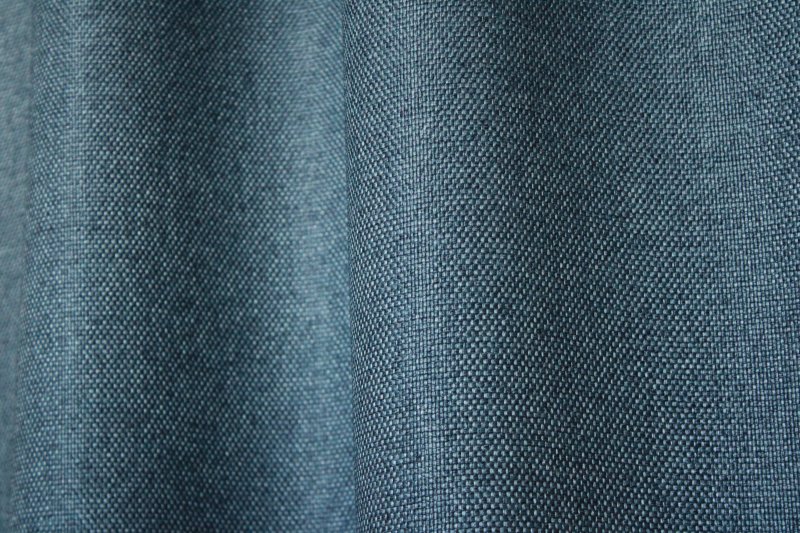 Sfeerfoto van donkerblauw verduisterend gordijn REY2549 uit de Blur Shade collectie, in de plooi met volle stof en diepe kleur.