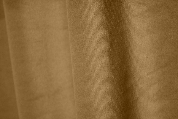 Stofpatroon van goudgele velvet gordijnen Renoir REY2537, close-up van de weving met volle fluweelstructuur. velours gordijnen in het goud