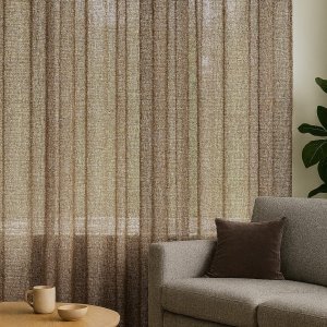 Inbetween gordijnen met metallic glans en fijne bronzen draad in een modern interieur, soepel vallend en lichtdoorlatend voor het raam.