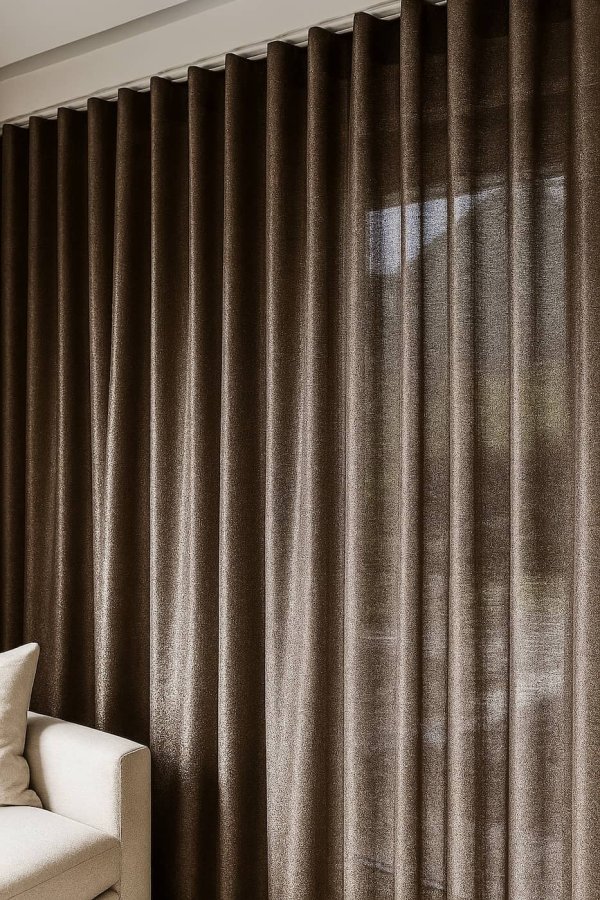 Sfeerfoto van linnen-lurex gordijnen in taupe, elegant vallend in een stijlvol ingerichte woonruimte.