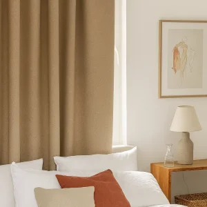 Verduisterend gordijn in zandkleurige Calm Shade-stof, elegant opgehangen in een rustgevend interieur met natuurlijke tinten.