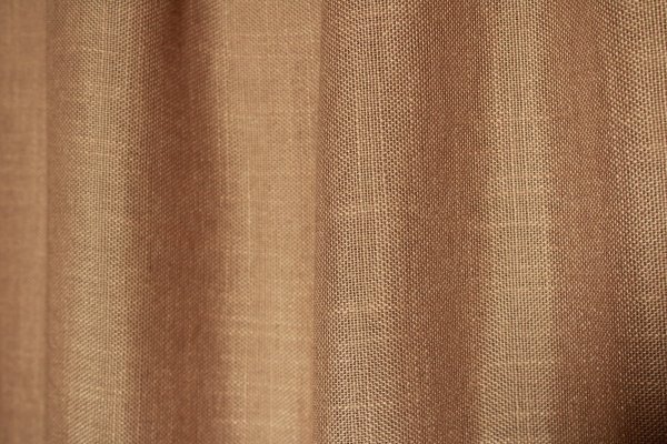 Gedraaid stofpatroon van de honingkleurige inbetween gordijnen met linnen look uit de Saphira Light collectie van Okika, met zicht op de warme kleur en natuurlijke weving.