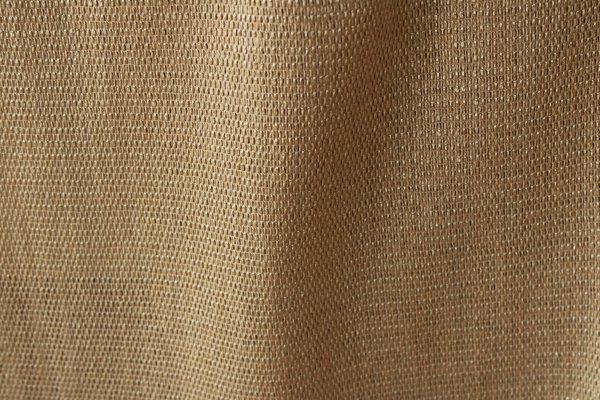 stofpatroonvan het beige inbetween gordijn Linea in de plooi, met zicht op de grove weving en kleurnuances.