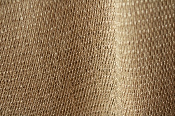 Grove geweven stof van het beige inbetween gordijn Linea met zichtbare garenstructuur in daglicht.