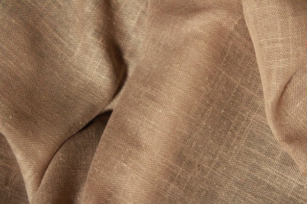 Gedraaid stofpatroon van de soft taupe inbetween gordijnen met linnen look uit de Saphira Light collectie van Okika, met zicht op de fijne weving en natuurlijke textuur.
