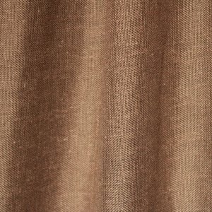 Sfeerfoto van de taupek leurige inbetween gordijnen met linnen look uit de Saphira Light collectie van Okika, soepel hangend en zacht licht doorlatend voor een warme sfeer.