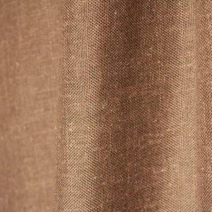 Stofdetails van de taupe kleurige inbetween gordijnen met linnen look uit de Saphira Light collectie van Okika, met zicht op de fijne vezelstructuur en zachte valling.