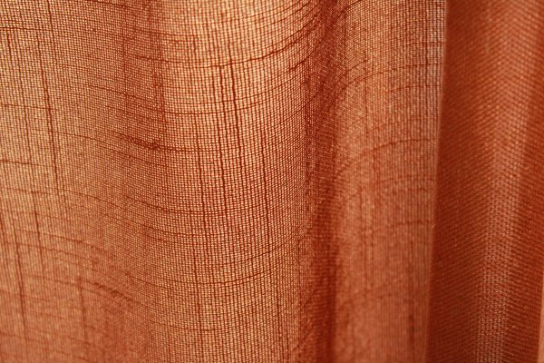 Stofstructuur van terra inbetween gordijnen met linnen look uit de Saphira Light collectie van Okika, lichtdoorlatend met zichtbare natuurlijke weving