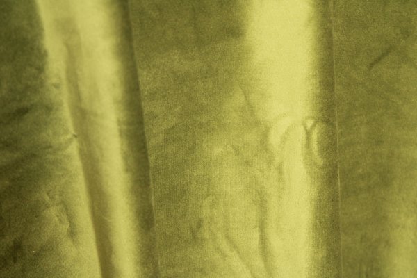 Detail van retrogroene fluwelen Okika gordijnen met velours acchtig stofpatroon en luxe uitstraling