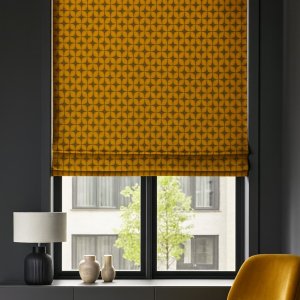 sfeerimpressie naar woonkamer met okergele vouwgordijnen in zachte retrostijl van Okika, met een gezellige en zonnige uitstraling.