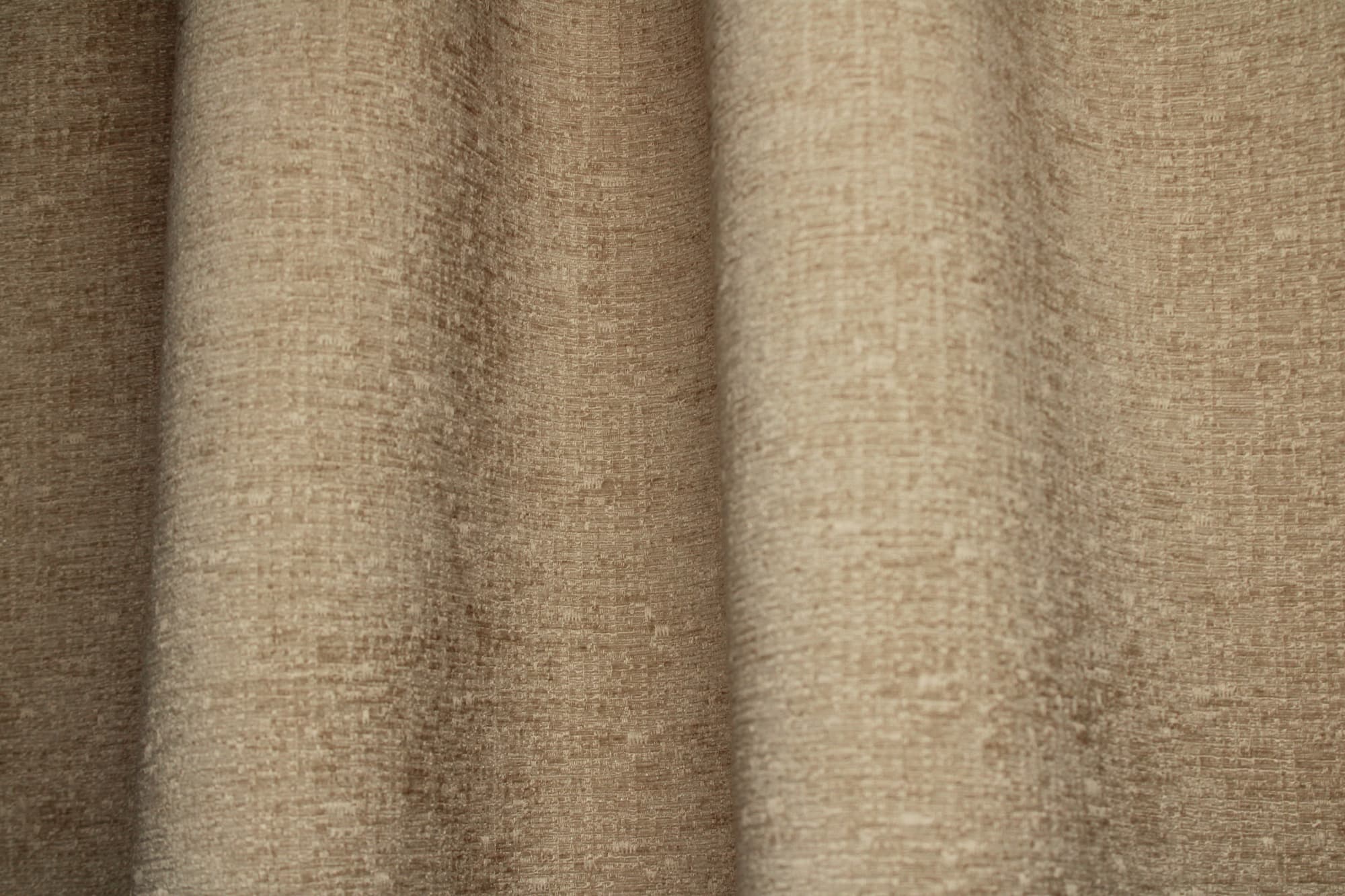 Sfeerfoto van beige teddy chenille gordijnen van Okika, getoond in de plooi bij daglicht zodat je een goed beeld krijgt bij gordijnen