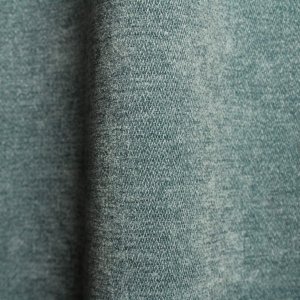 Stofdetails van blauwe chenille gordijnen van Okika, chenille structuur mooi in beeld.