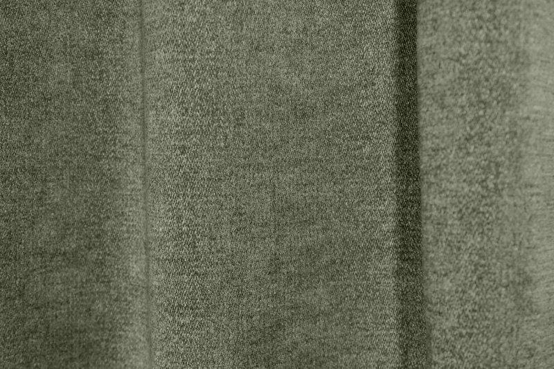 Sfeerfoto van groene chenille gordijnen van Okika, hangend in de plooi.