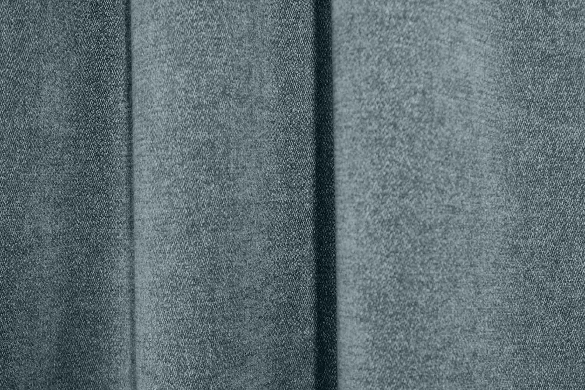 Sfeerfoto van petrol kleurige chenille gordijnen van Okika, waarbij de gordijnen hangen in de plooi.