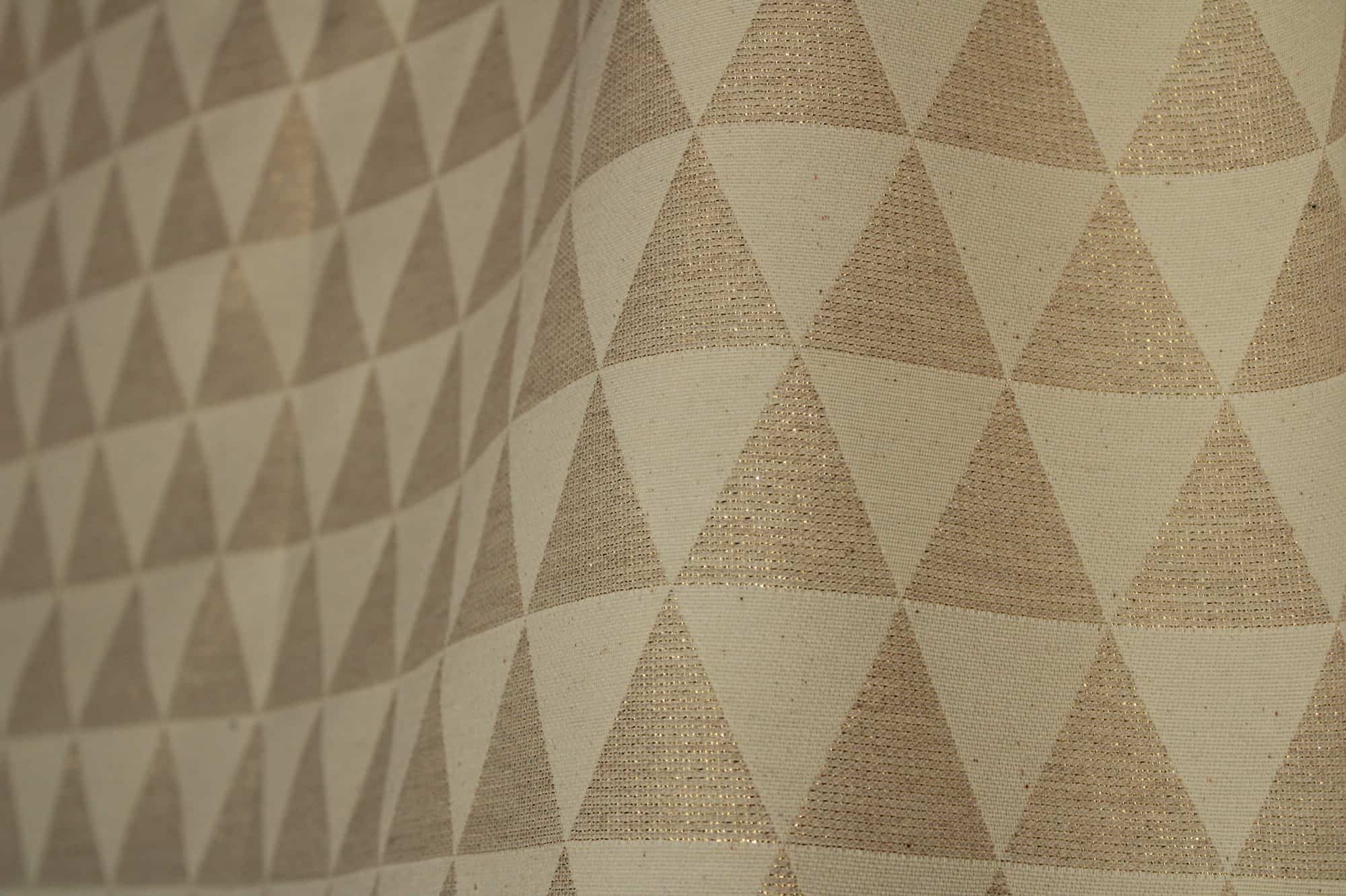 Stofdetail van beige glitter gordijn met driehoekpatroon