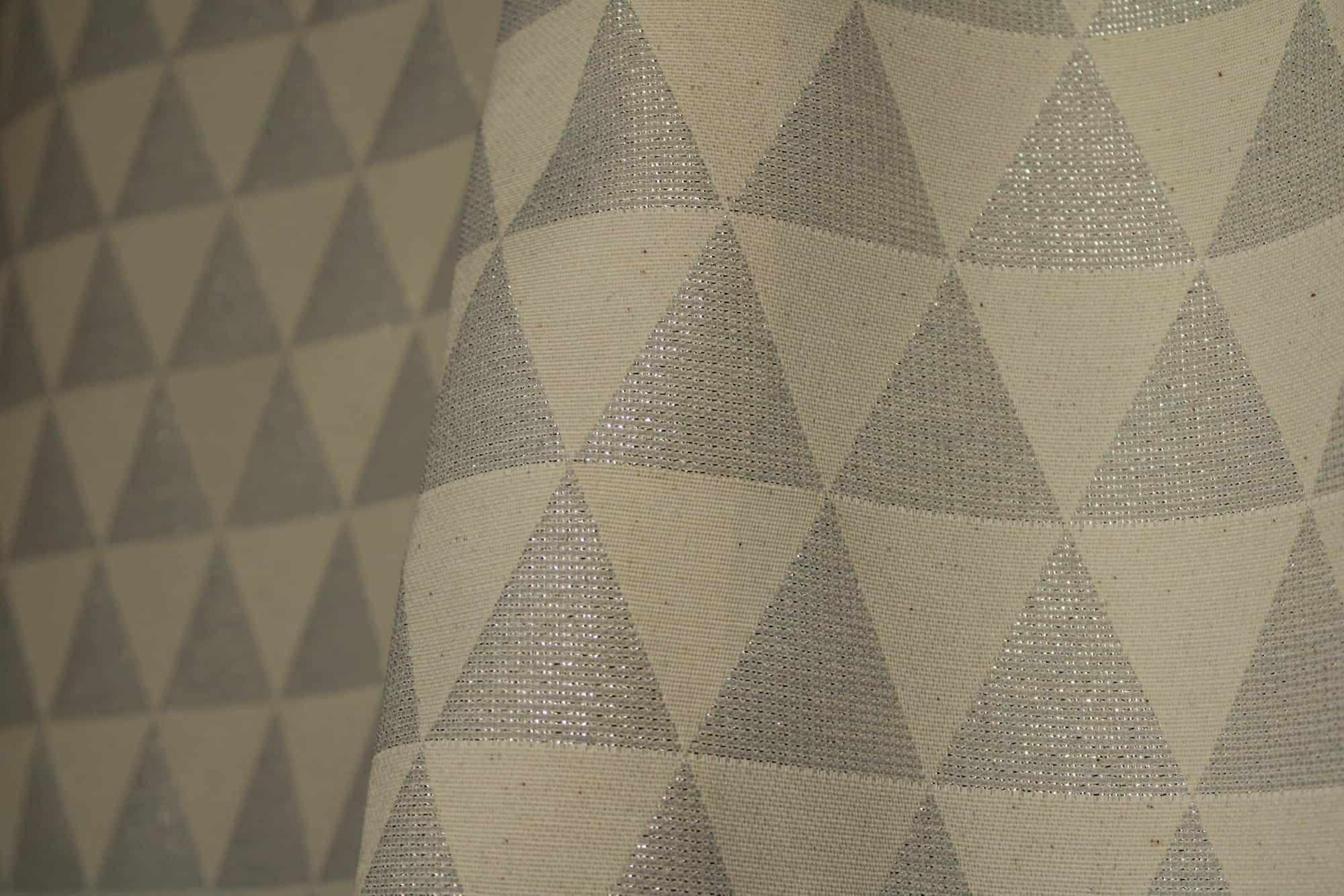 Stofdetail van zilveren glitter gordijn met driehoekpatroon
