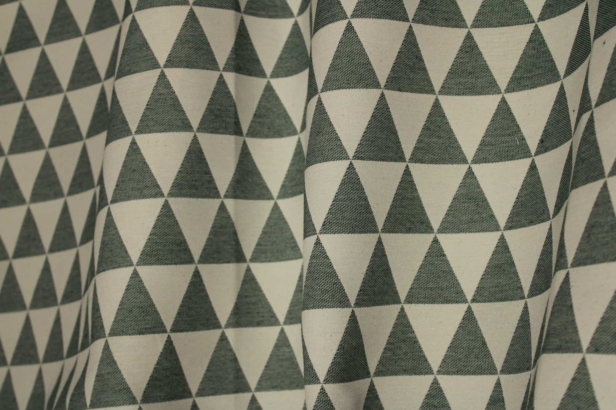 Sfeershot van groene gordijnen met ingeweven driehoekpatroon.