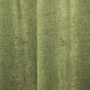 Sfeerfoto van groene chenille gordijnen van Okika, getoond in de plooi, met een rustige uitstraling en zachte lichtinval in het interieur.