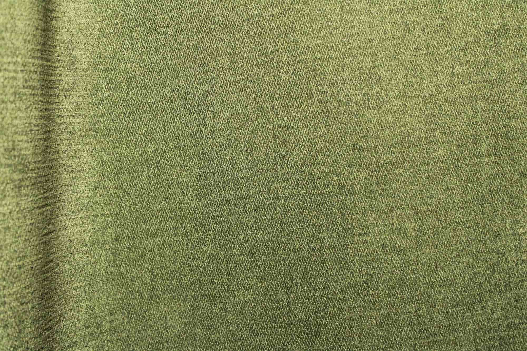 Stofdetails van groene chenille gordijnen van Okika, met een zachte structuur en gelijkmatige weving zichtbaar bij natuurlijk licht.