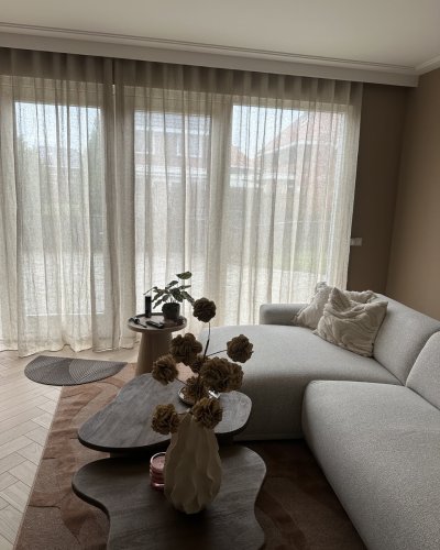 linnen-maison-creme-woonkamer-klant-wavegordijn (1) inbetween linnen gordijn Maison in crème, opgehangen als wavegordijn bij een klant in de woonkamer. De natuurlijke linnen structuur en zachte plooien zorgen voor een rustige, lichte sfeer met warm daglicht.