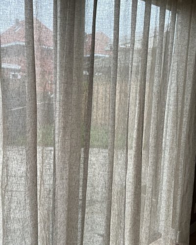 linnen-maison-creme-woonkamer-klant-wavegordijn-closeup (1) close-up van een inbetween linnen gordijn Maison in crème bij een klant in de woonkamer. Het wavegordijn valt soepel en laat het licht zacht door, wat de ruimte een rustige, natuurlijke sfeer geeft.