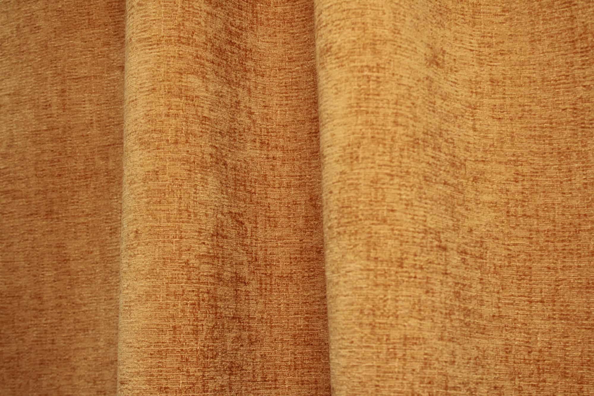 Sfeerbeeld van okergele teddy chenille gordijnen van Okika, waarbij de gordijnen in de plooi hangen