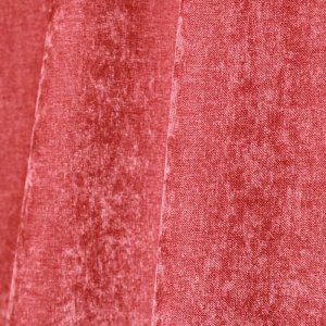 Sfeer foto van oudroze chenille gordijnen in een plooi, met de zachte krijtstructuur subtiel zichtbaar.