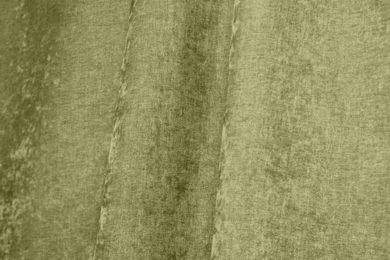 Sfeerfoto van pistachekleurige chenille gordijnen in een plooi, met subtiele krijtstructuur.