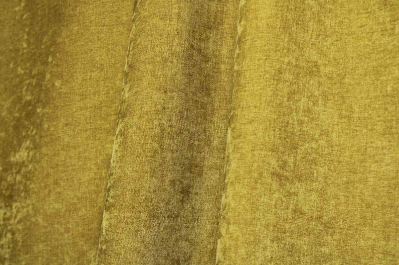 Sfeerfoto van pistachekleurige chenille gordijnen in een plooi, met subtiele krijtstructuur.