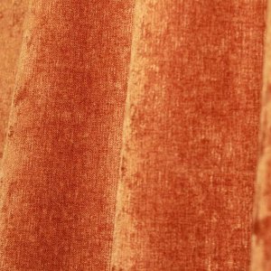 Close-up van de roestkleurige chenille krijtstof, waarin de structuurl mooi naar voren komen