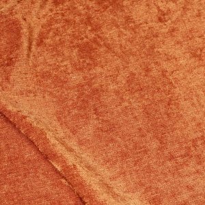 detail foto van de roestkleurige chenille gordijnen, waarbij de fijne stofstructuur met krijt effect duidelijk zichtbaar is.