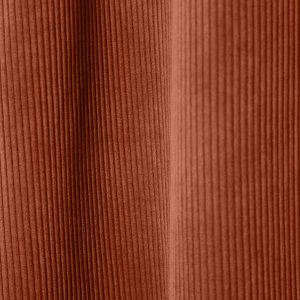 Sfeerbeeld van roodbruine ribstof gordijnen uit collectie SYM2603, waarbij de stof in plooien hangt en warmte toevoegt aan het interieur. Dit is een sfeerfoto met ribstof gordijnen in plooien.